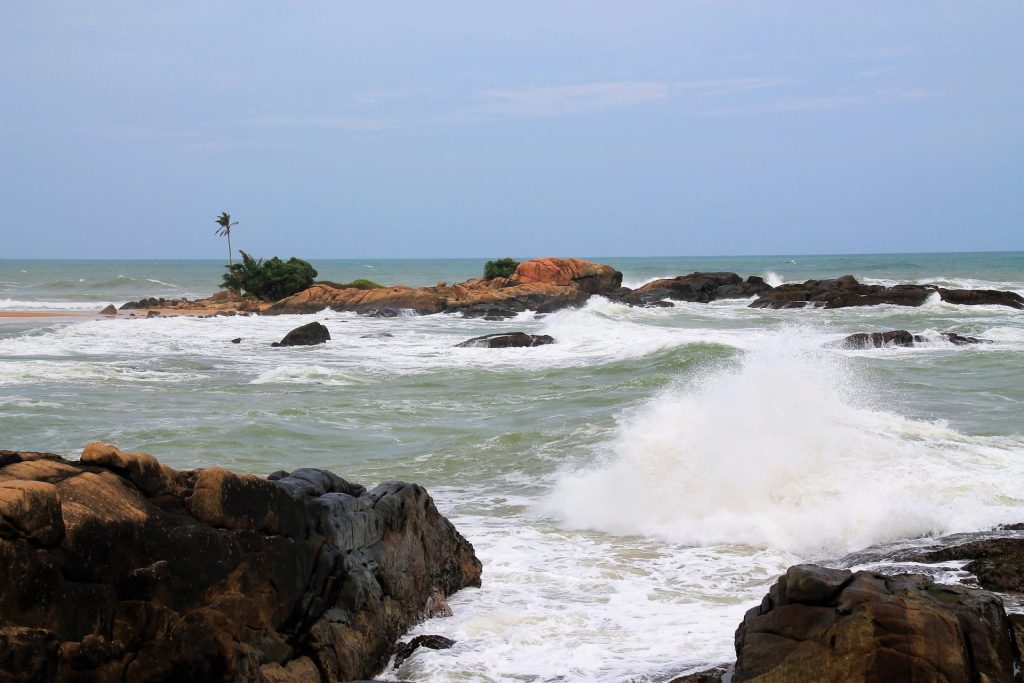 Little island and the stormy sea at Dodanduwa harbour 